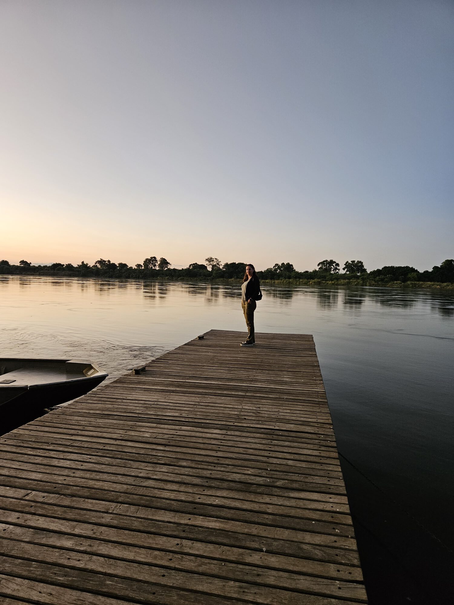 Kelly on a wooden jetty at sunset on the Zambezi River, Zambia