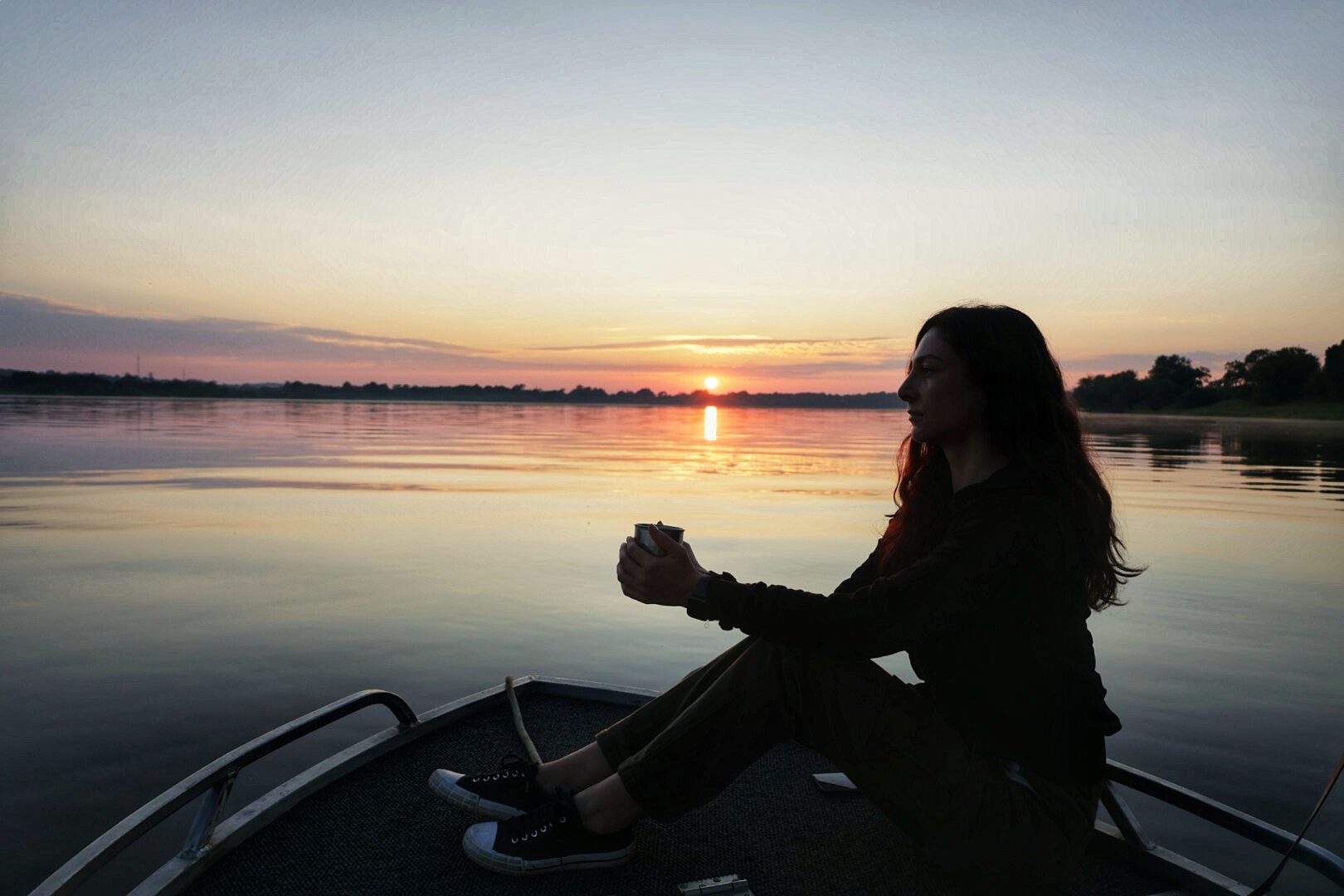 Kelly on the bow of a boat at sunset on the Zambezi River, Zambia